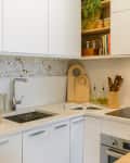 white kitchen with white cabinets and terazzo backsplash