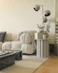 white living room with large white cozy sofa and large unique coffee table