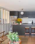White kitchen with tile walls and black cabinets and kitchen island