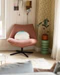 Circular accent tables in living room with pink chair.