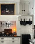 Black painted ceiling in kitchen with white subway tiles.