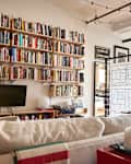 A living room with a large bookcase filled with books.