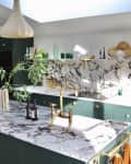 Kitchen with green cabinets, marble island, and dining area.