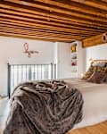 Bed with decorative pillows and blankets.