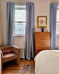 white bedroom with red zebra wallpaper accent wall and light blue curtains