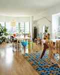 Living room with large windows and two tables.