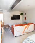 White studio apartment with bedroom and living room with TV visible