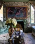 Living room layered with floral wallpaper, floral brocade sofa and cream shag rug.