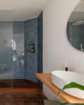 Blue tiled shower in bathroom.