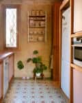 Pink cabinets in historic apartment with patterned tiles.