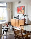 View of living room with large white couch and dining room with table spaces