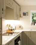 White kitchen with sage green cabinetry with gold hardware