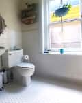 White hexagonal tile in bathroom before renovation.