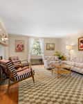 Living room with floral and striped upholstered furniture and checkered area rug