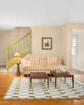 Living room with striped upholstered furniture and checkered area rug