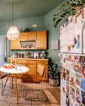 Vintage chairs and hanging pendant in green kitchen