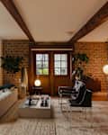 A living room with expose supports and mid-century modern furniture.