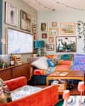 Framed art and maximalist decor in blue living room