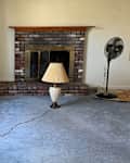 Lamp in front of fireplace in empty living room.