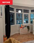 A cozy children's bedroom featuring a loft bed, wooden flooring, a toy storage box, and a large window with black curtains.