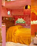 Marigold yellow comforter on neatly made bed in vintage inspired RV.