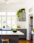 White beadboard in a farmhouse kitchen with dark gray cabinets and white countertops
