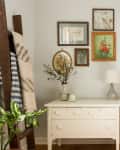a peaceful bedroom features a leaning ladder, bed and side table, all in neutral tones