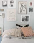Bedroom with a gallery wall, striped bedding, and polka dot pillows, adjacent to a small kitchen with white cabinets.