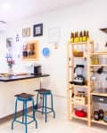 Bright kitchen with white cabinets, black countertop, bar stools, open shelving, and wall decor.