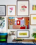 A gallery wall of colorful art prints in a living room
