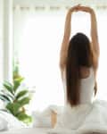 Woman stretching in bed.
