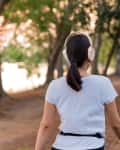 Woman wearing headphones walking on a trail