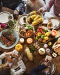 Crowded thanksgiving table filled with food, parents, and kids