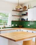 Modern kitchen with wood counters and bright green backsplash