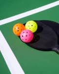 Close up of pickleball paddles and balls on court