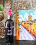 Bottle of port beside a painting.