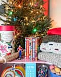 Various thriftmas gifts in front of tree.