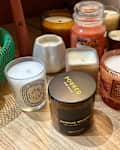 Various pumpkin spice scented candles on wooden surface.