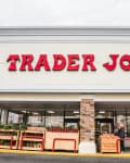 Trader Joe's storefront with red signage, stone accents, and outdoor produce display.