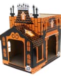 Cardboard cat house designed as a Halloween-themed haunted mansion with orange and black details.