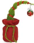 Curved green plant in red sack with red ribbon and ornament.