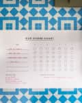 Chore chart on blue geometric wall with broom and dustpan hanging beside it.