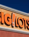 Big Lots store sign with bold orange letters on a stucco wall.