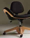 Modern black office chair with wooden base and adjustable seat on casters.