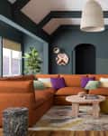 Living room with gray-green walls and brown-orange sectional