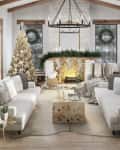 Cozy living room with Christmas tree, white sofas, fireplace, and holiday decor. Snowy view through large windows.