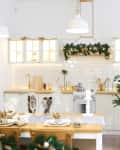 Christmas-themed kitchen with decorated tree, garlands, and a set dining table with festive decor.