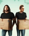 Two men holding labeled moving boxes, one for the living room and one for the kitchen, with furniture icons in the background.