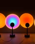 Four lamps projecting circles in sunset colors on wall