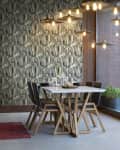 Dining area with geometric wallpaper, modern pendant lights, a white table, and black chairs.